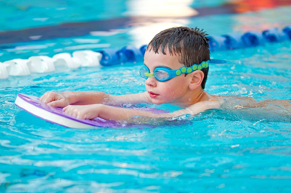 a boy swimming with a floatation device